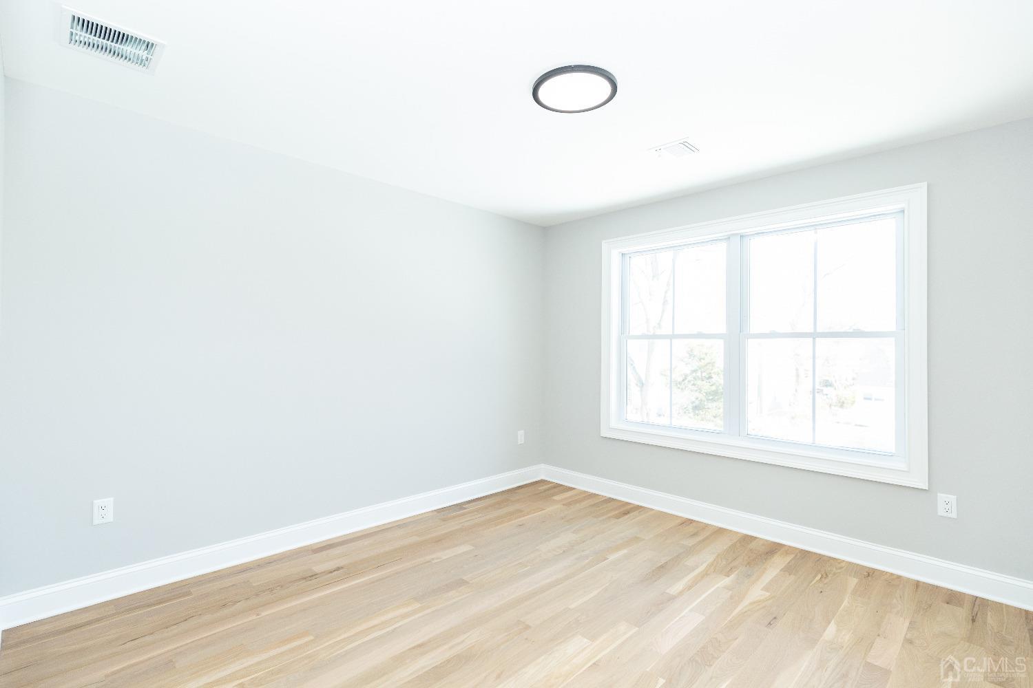 60 Brookville Road Edison, NJ 08817 - Photo 39 of 56 an empty room with wooden floor and windows