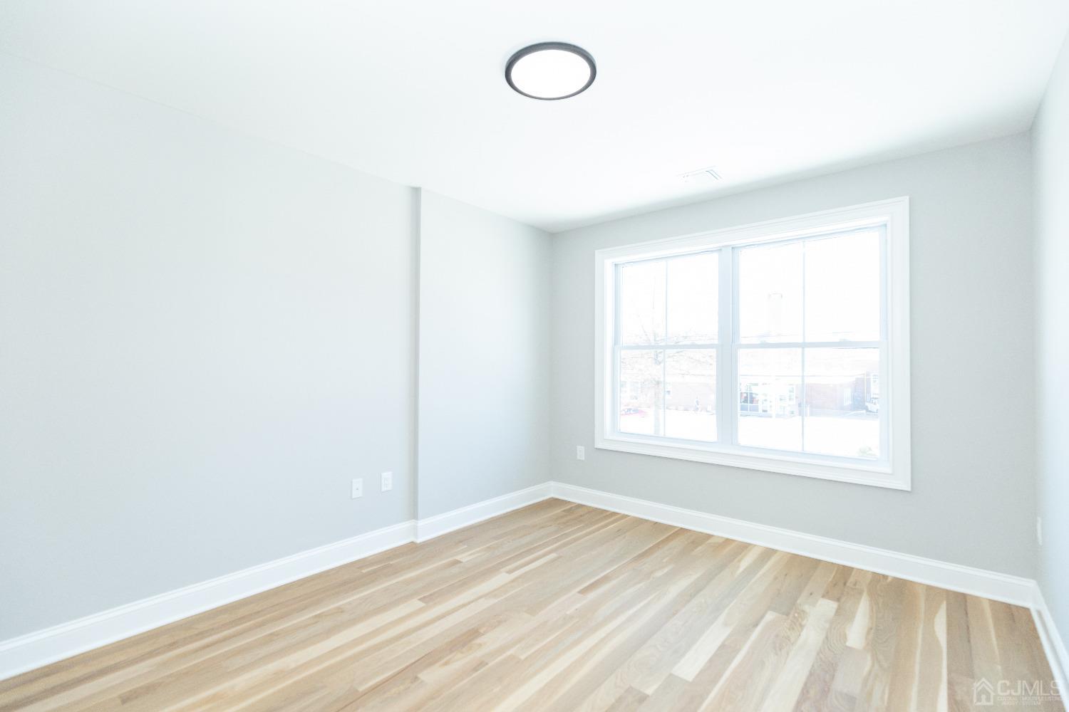 60 Brookville Road Edison, NJ 08817 - Photo 46 of 56 an empty room with wooden floor and windows