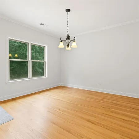 a view of a room with wooden floor windows and a chandelier
