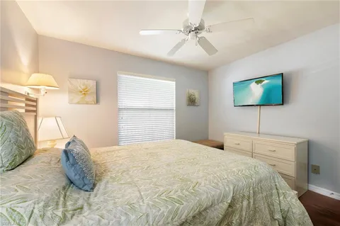 a bedroom with a large bed and a flat tv screen on dresser