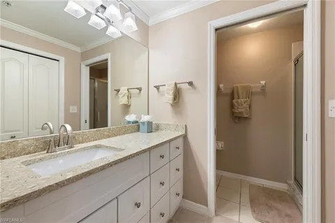 a bathroom with a granite countertop sink a mirror and a shower