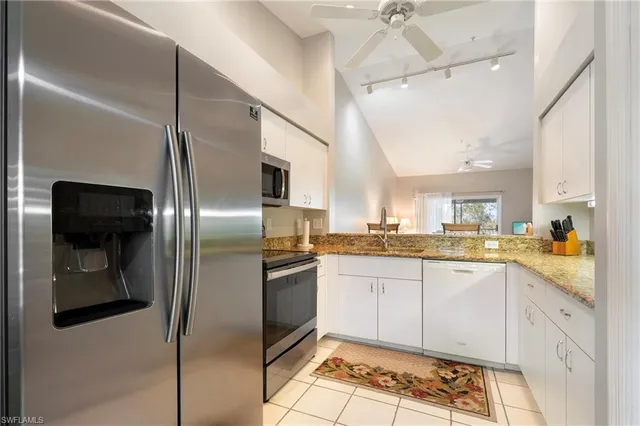 a kitchen with stainless steel appliances granite countertop a sink a stove and a refrigerator
