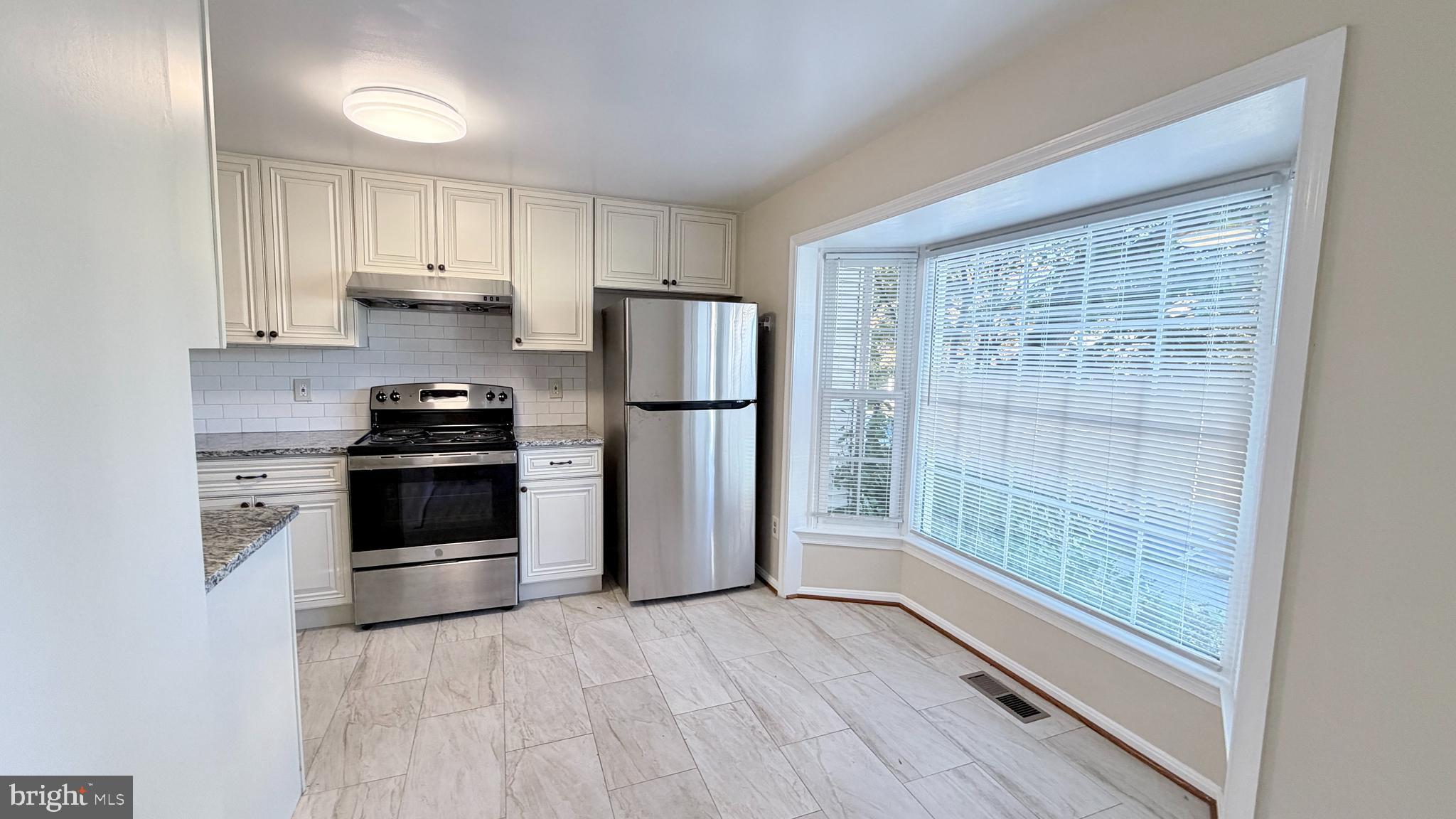 122 Sharpstead Lane Gaithersburg, MD 20878 - Photo 2 of 43 a kitchen with a refrigerator a stove top oven and wooden floor