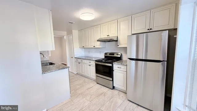 a kitchen with white cabinets and stainless steel appliances