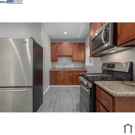 a kitchen with stainless steel appliances granite countertop a stove a refrigerator and a sink