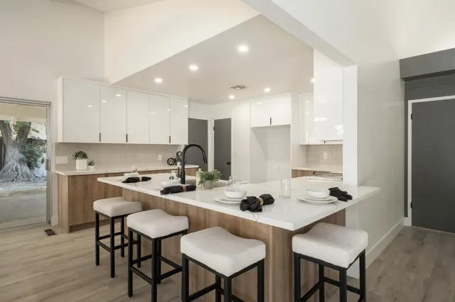 a kitchen with a dining table cabinets and refrigerator