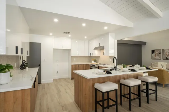 a kitchen with a sink and chairs