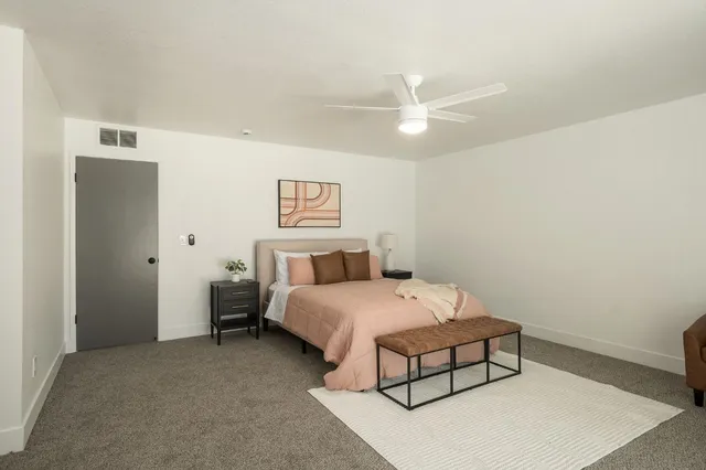 a spacious bedroom with a bed and a chandelier