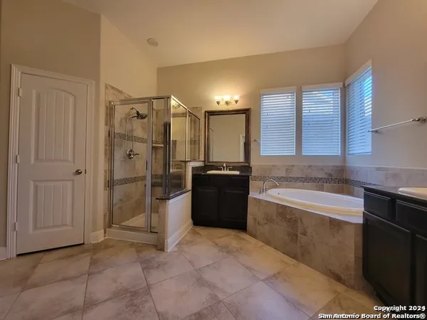 a large bathroom with a tub a sink and a large mirror