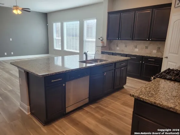 a kitchen with granite countertop a sink and a stove