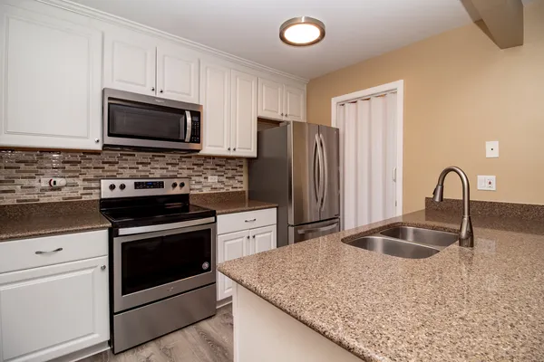 a kitchen with stainless steel appliances granite countertop a sink stove and refrigerator