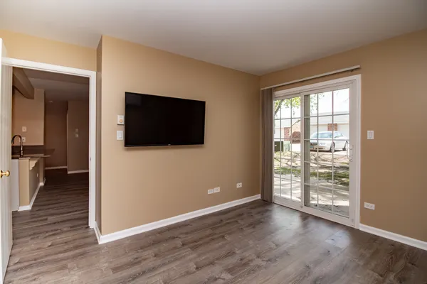 a view of a livingroom with wooden floor and a flat screen tv
