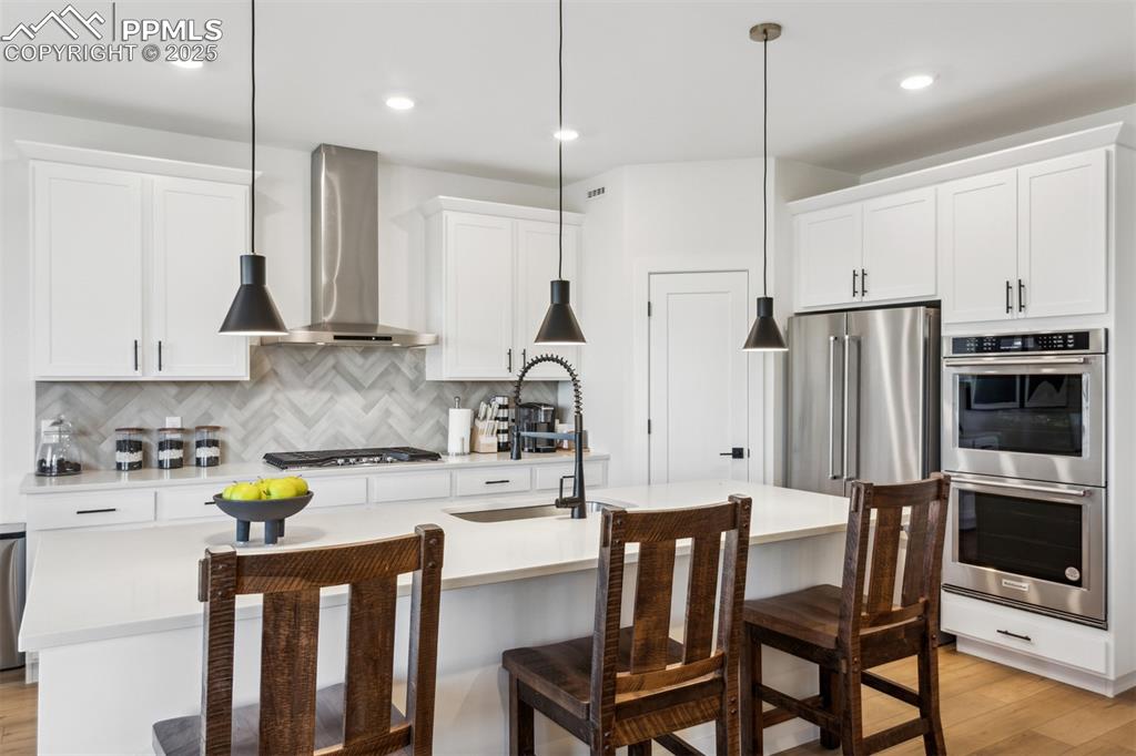 42973 Colonial Trail Elizabeth, CO 80107 - Photo 2 of 10 a kitchen with stainless steel appliances granite countertop a sink a stove a refrigerator cabinets a dining table and chairs