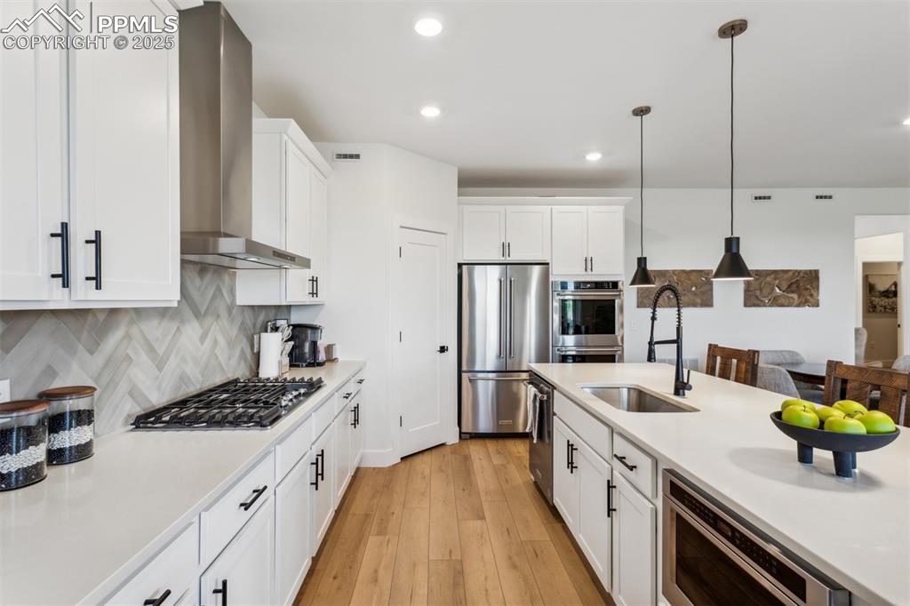 42973 Colonial Trail Elizabeth, CO 80107 - Photo 3 of 10 a kitchen with stainless steel appliances a sink a stove a refrigerator wooden floor and cabinets