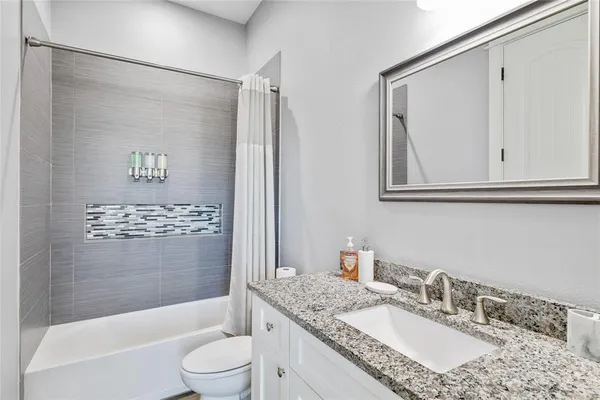 a bathroom with a granite countertop sink toilet and shower