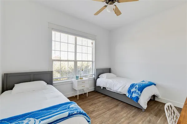 a bedroom with a bed a chandelier and a window