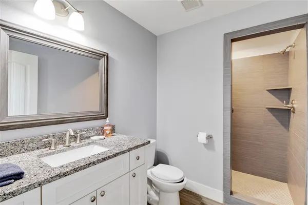 a bathroom with a granite countertop sink toilet and shower