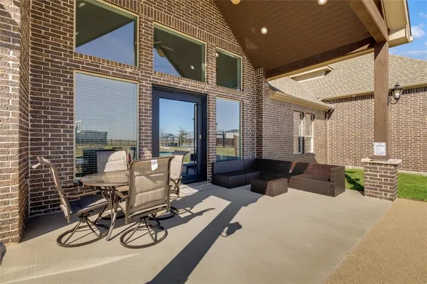 a view of a patio with furniture and floor to ceiling window