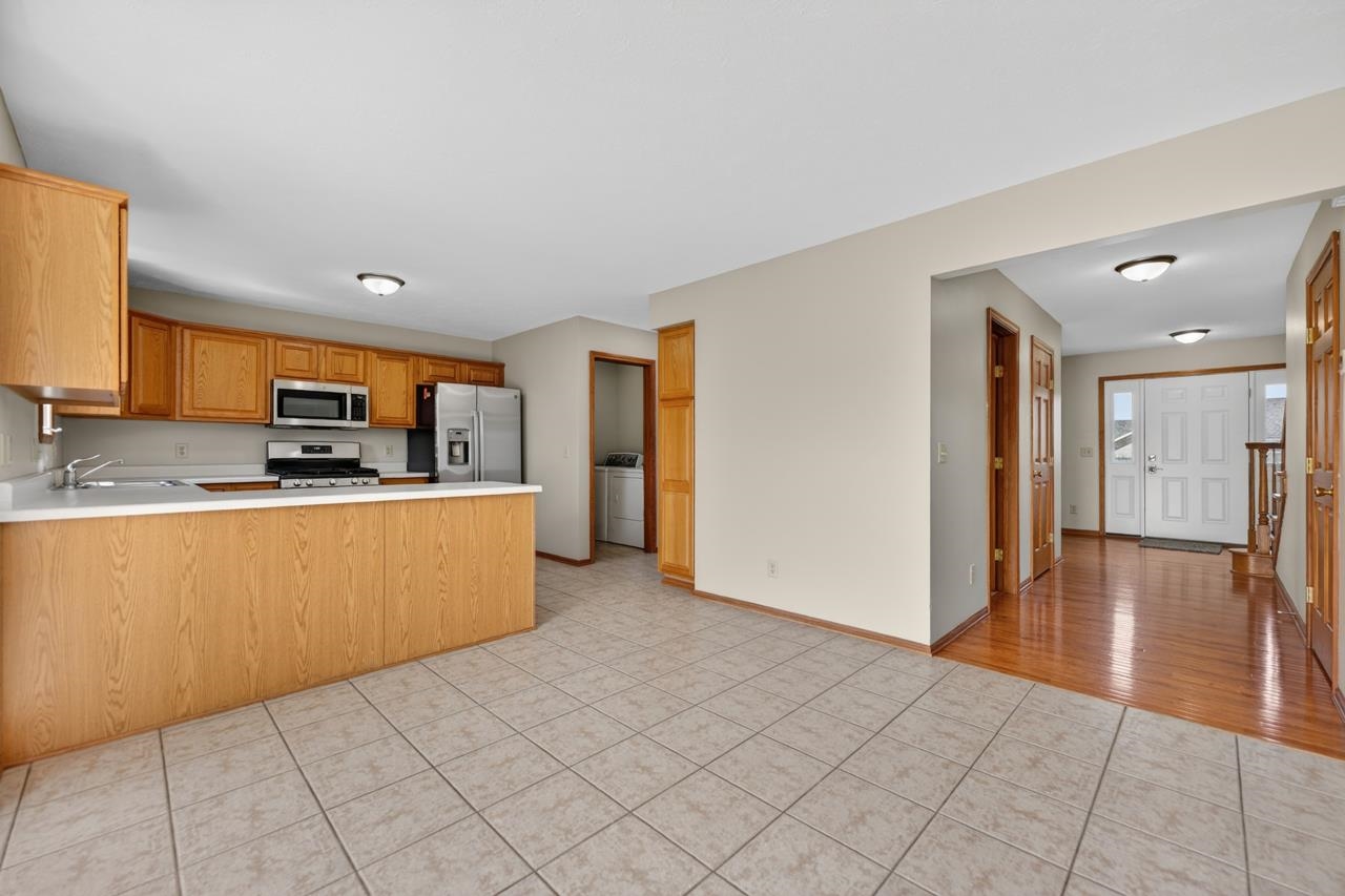 676 Elberon Way Roscoe, IL 61073 - Photo 14 of 30 a large kitchen with stainless steel appliances granite countertop a refrigerator and a stove top oven