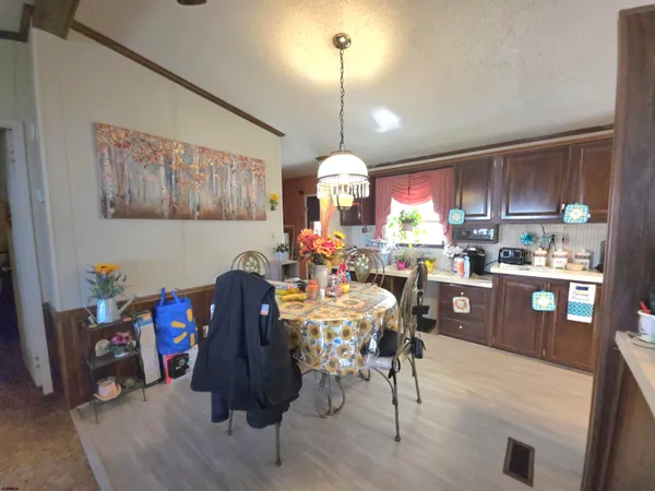 a kitchen with granite countertop a dining table chairs stainless steel appliances and cabinets