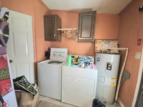 a utility room with fridge dryer and washer
