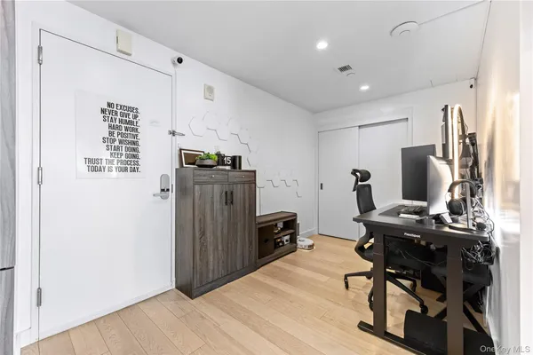 a view of a workspace with furniture and wooden floor