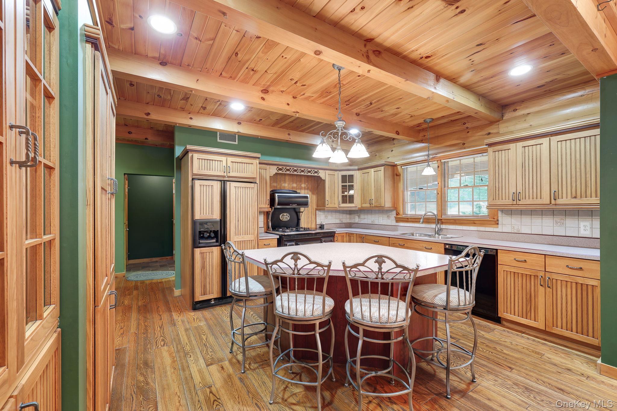 230 Post Road Slate Hill, NY 10973 - Photo 7 of 26 Kitchen featuring a multi-sided island with seating, exposed wood beam ceiling, light wood cabinetry, and recessed lighting.