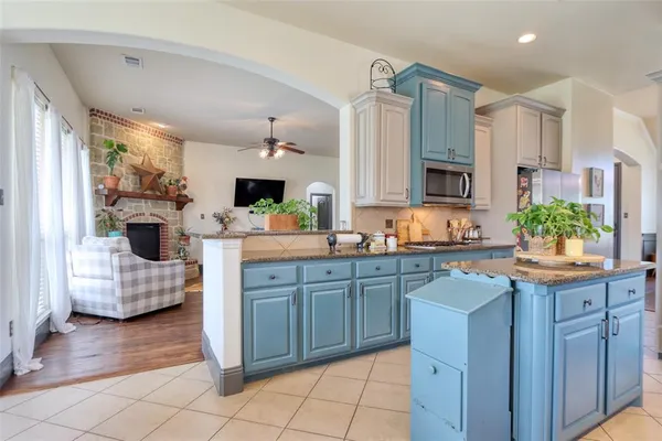a kitchen with kitchen island granite countertop a sink cabinets and stainless steel appliances