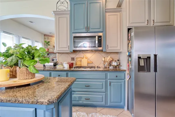 a kitchen with granite countertop a sink a stove and a refrigerator