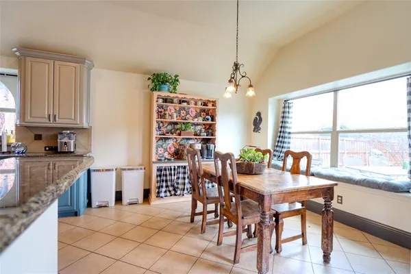 a dining room with furniture a chandelier and window