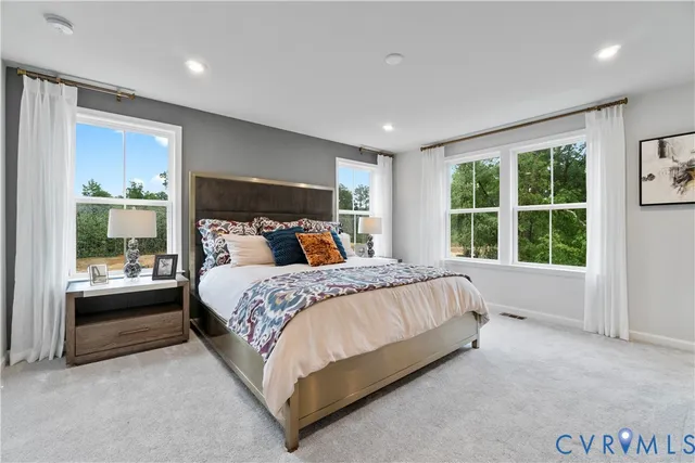 a bed sitting in a spacious bedroom next to a window