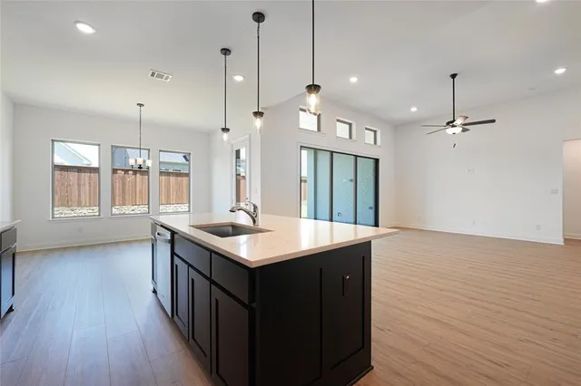 a kitchen with a sink window and wooden floor