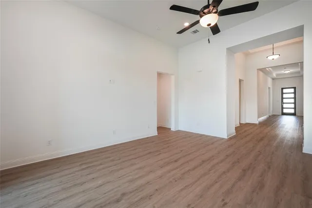 an empty room with wooden floor a ceiling fan and closet