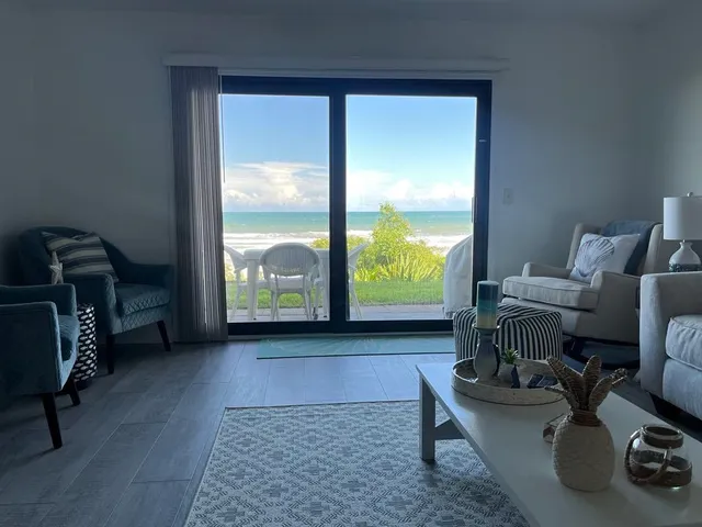 a living room with furniture and a floor to ceiling window