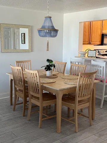 a view of a dining room with furniture a chandelier and wooden floor