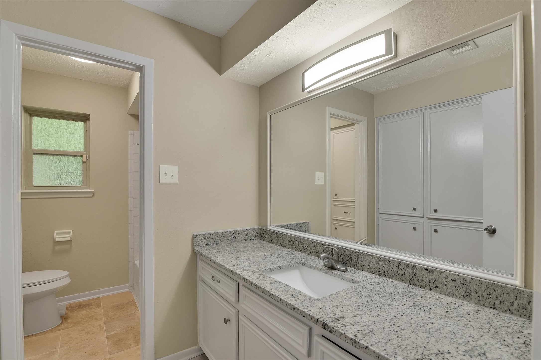 345 Maple Lane Conroe, TX 77304 - Photo 19 of 35 a bathroom with a granite countertop sink and mirror with toilet