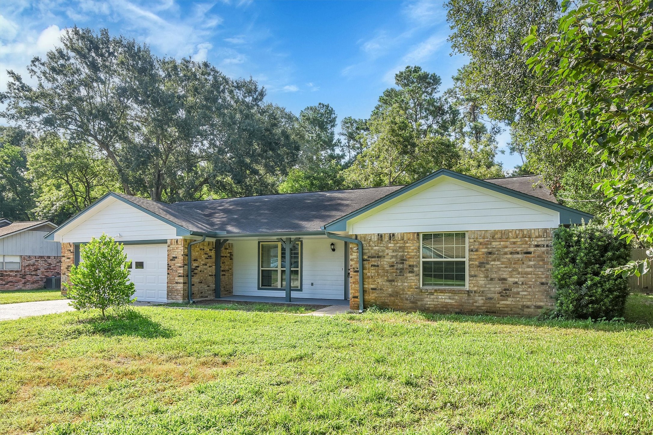 345 Maple Lane Conroe, TX 77304 - Photo 2 of 35 a front view of a house with a garden