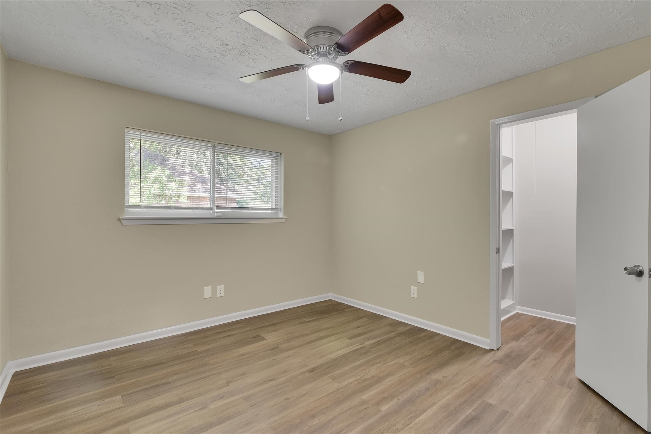 345 Maple Lane Conroe, TX 77304 - Photo 22 of 35 an empty room with wooden floor and windows