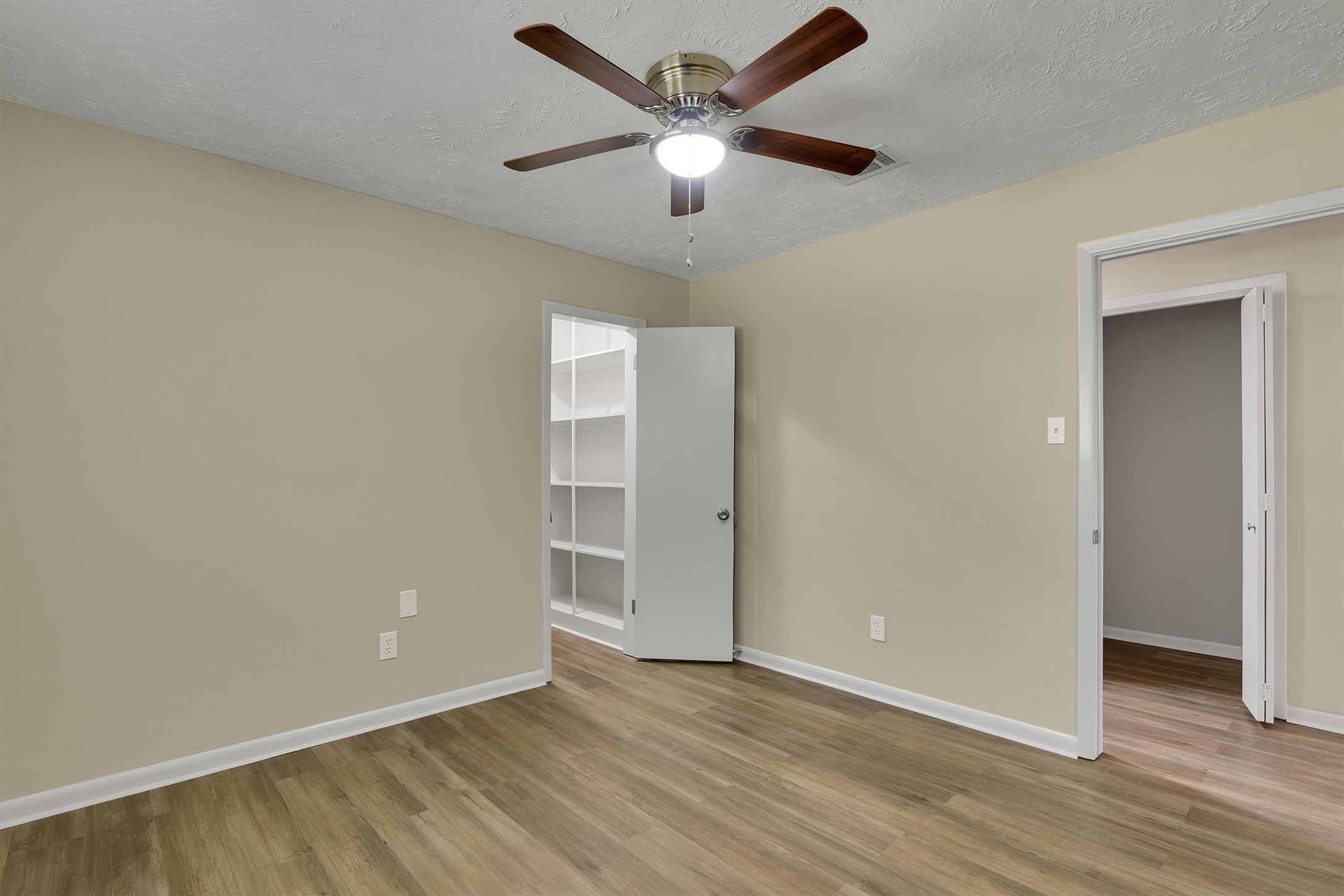 345 Maple Lane Conroe, TX 77304 - Photo 23 of 35 an empty room with wooden floor and ceiling fan