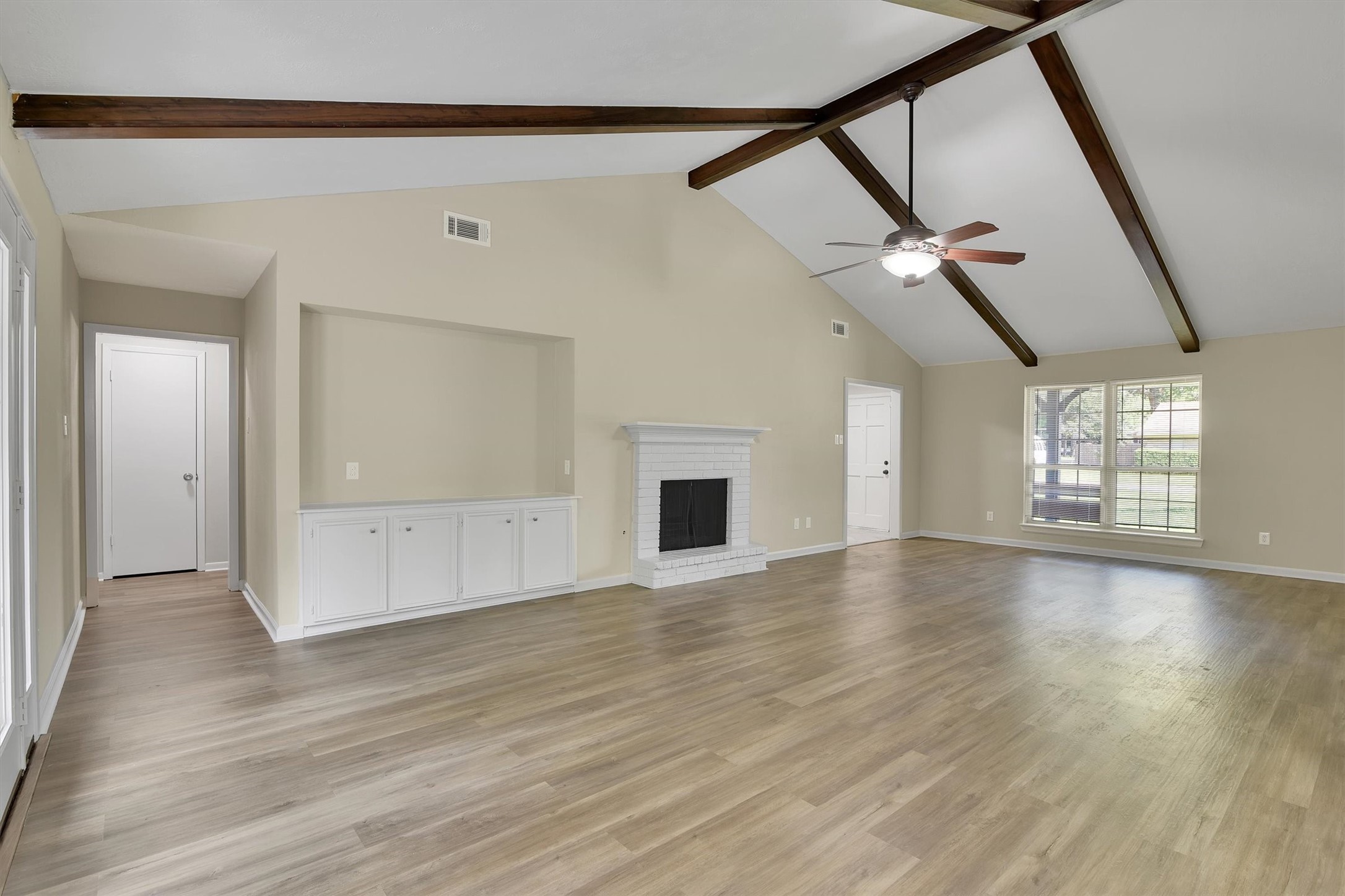 345 Maple Lane Conroe, TX 77304 - Photo 6 of 35 a view of an empty room with wooden floor and a window