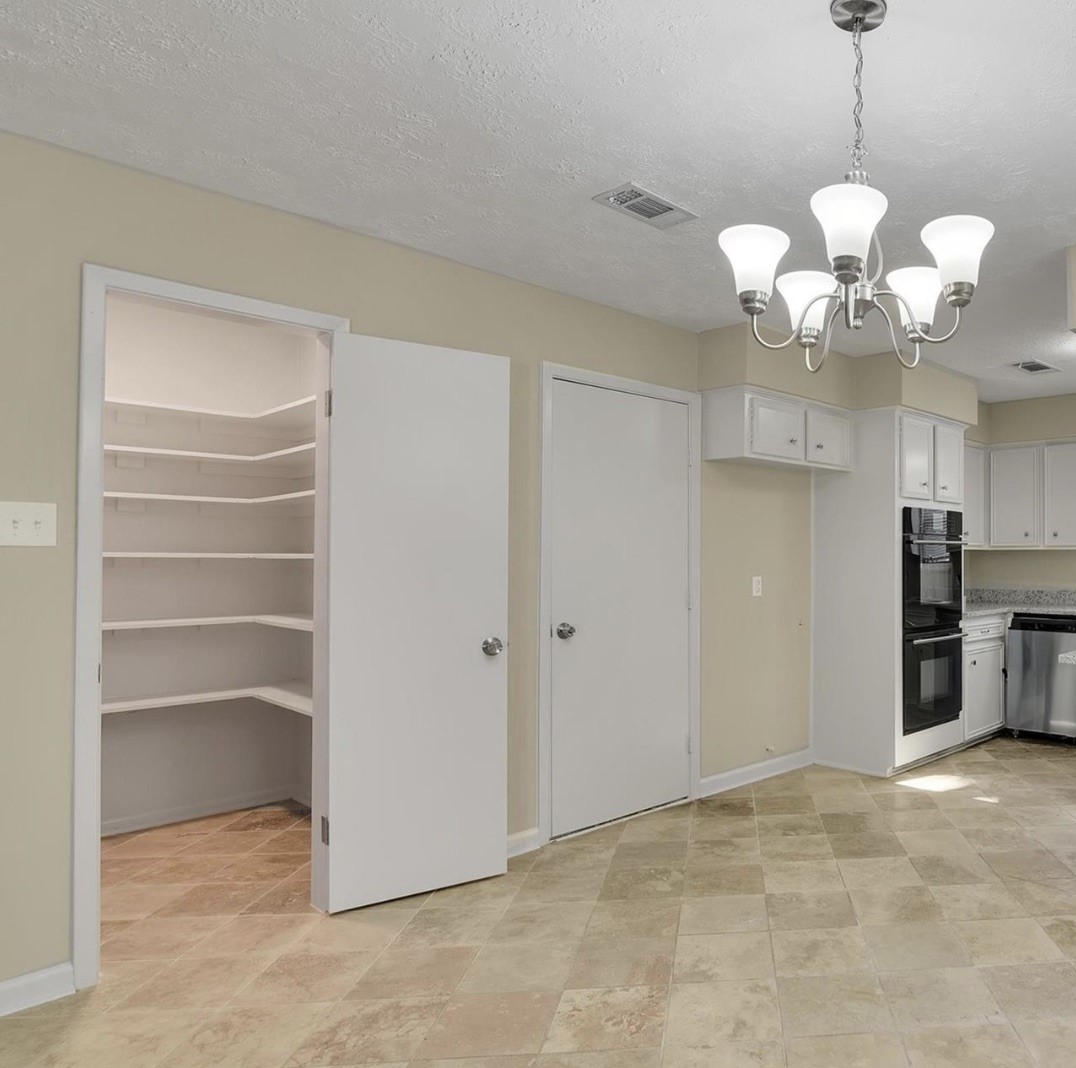 345 Maple Lane Conroe, TX 77304 - Photo 10 of 35 a view of a kitchen with a chandelier