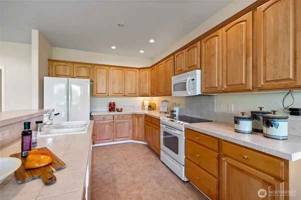 a large kitchen with stainless steel appliances granite countertop a stove sink and cabinets