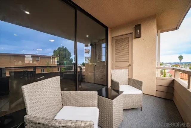 a living room with stainless steel appliances furniture and a view of kitchen