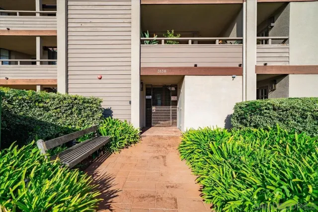 a front view of a building with a garden and entryway