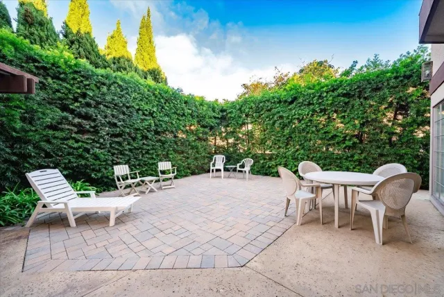 a view of a patio with a table and chairs and potted plants