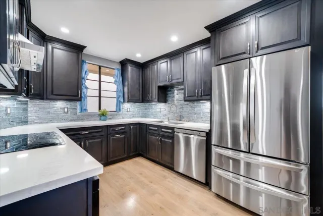 a kitchen with stainless steel appliances granite countertop a refrigerator a sink dishwasher a stove and a microwave oven on granite countertops
