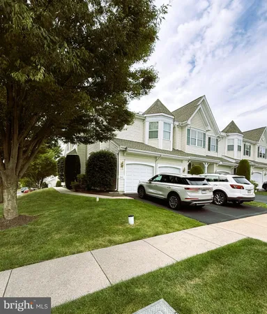a view of yard with car parked in front of house