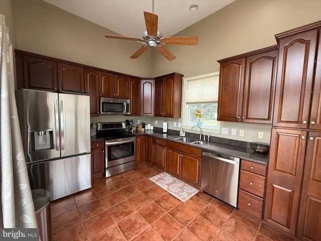 a kitchen with stainless steel appliances granite countertop a refrigerator stove and sink