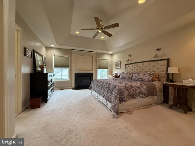 a large bedroom with a large bed a flat tv screen and a fireplace