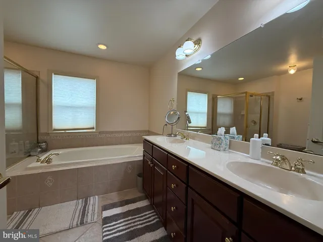 a bathroom with a sink mirror vanity and a bathtub